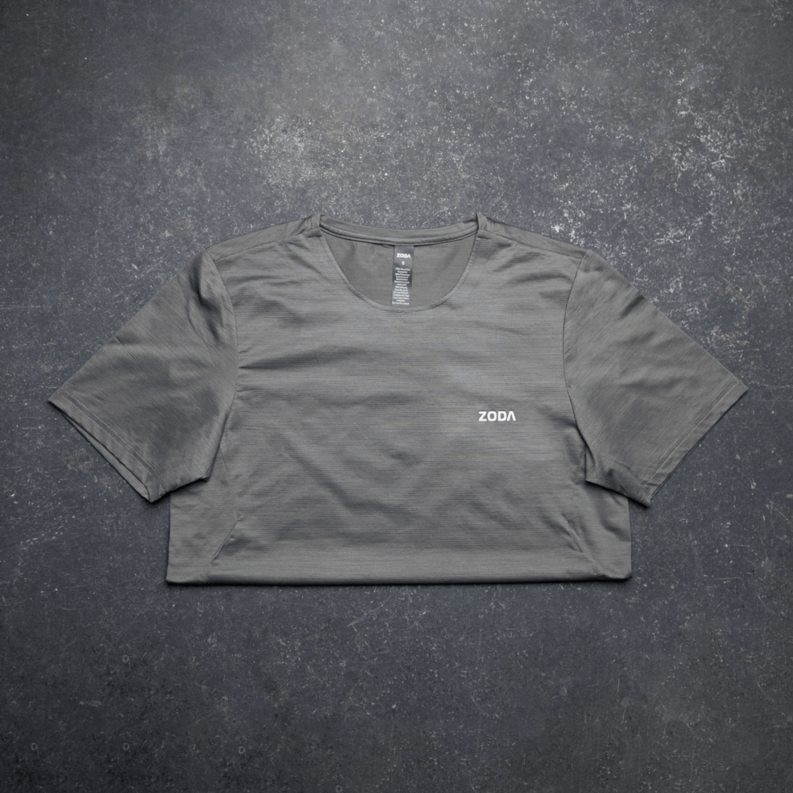Gray t-shirt with 'ZODA' logo on a dark textured surface Zoda.sg