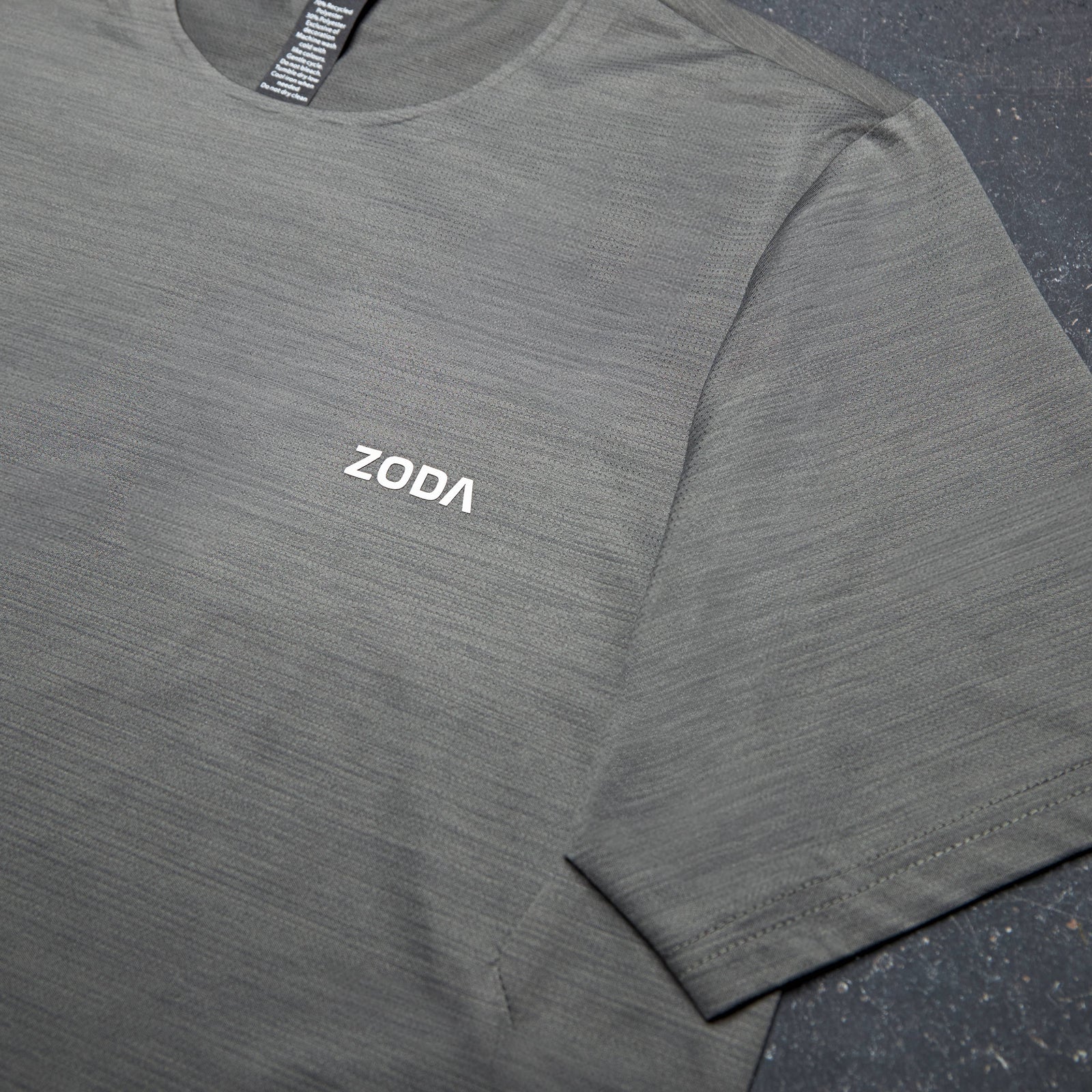 Gray long-sleeve shirt with 'ZODA' logo on a dark surface Zoda.sg