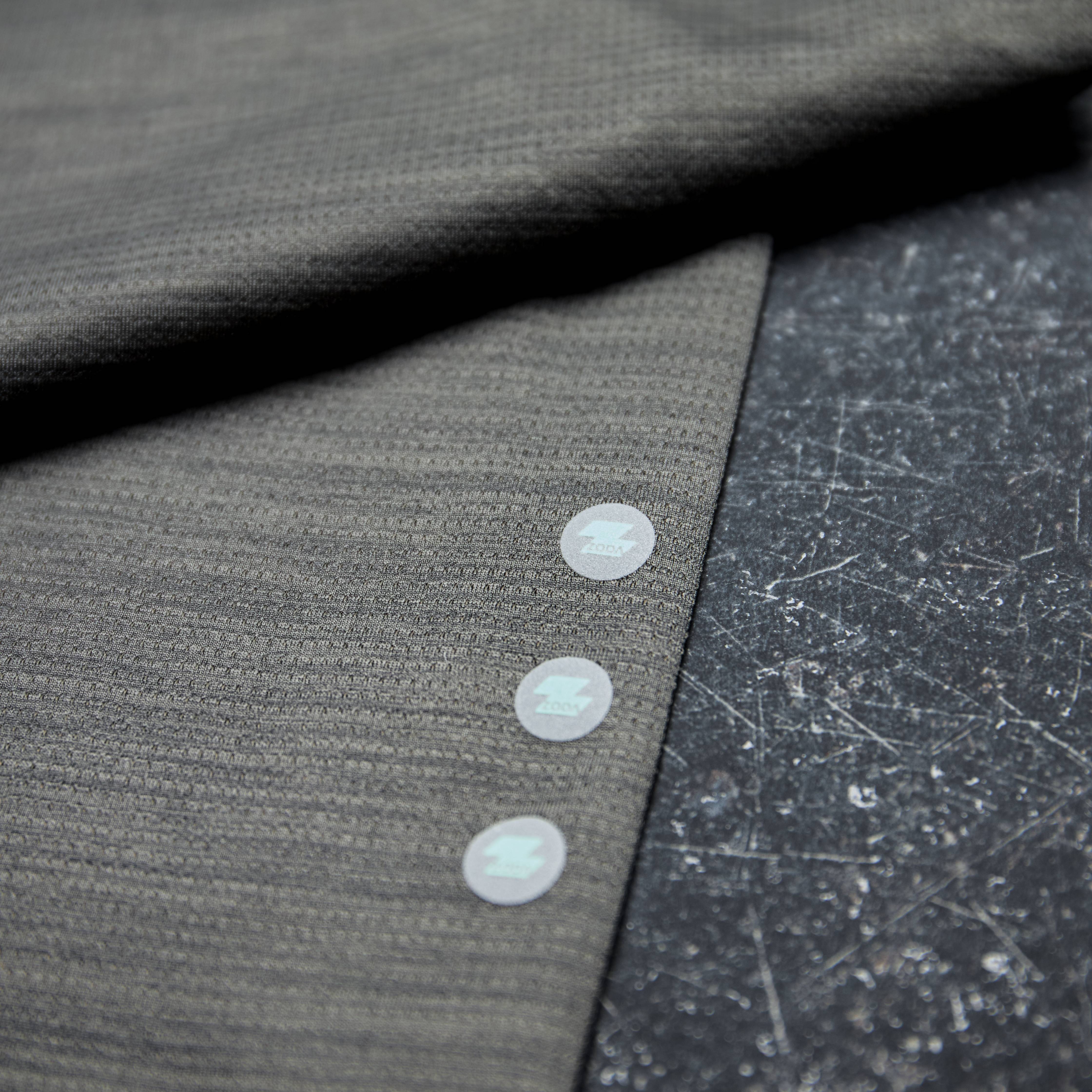 Close-up of a gray fabric with buttons on a textured surface Zoda.sg