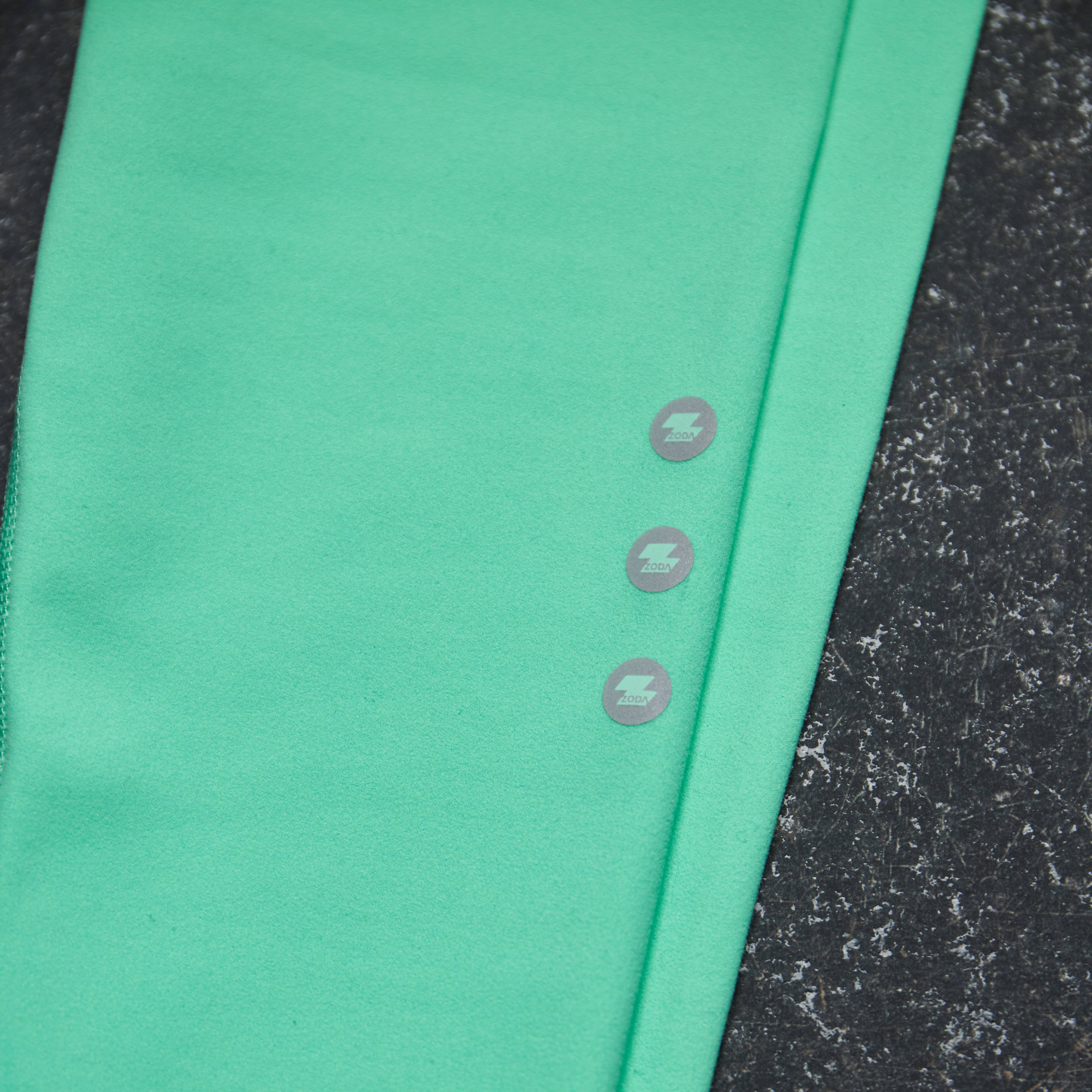 Green fabric with button details on a textured black surface Zoda.sg
