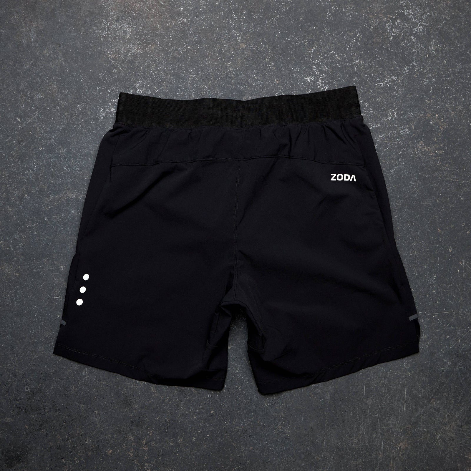 Black shorts with a brand logo on a gray surface Zoda.sg