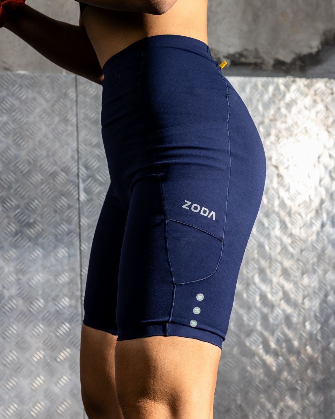 Zoda.sg Navy blue athletic shorts with 'ZODA' branding on a textured gray background
