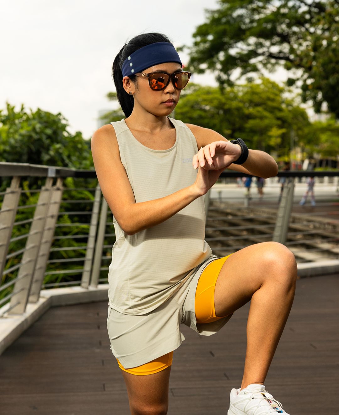 Girl in athletic wear stretching outdoors on a wooden path with greenery in the background Zoda.sg pulse collection