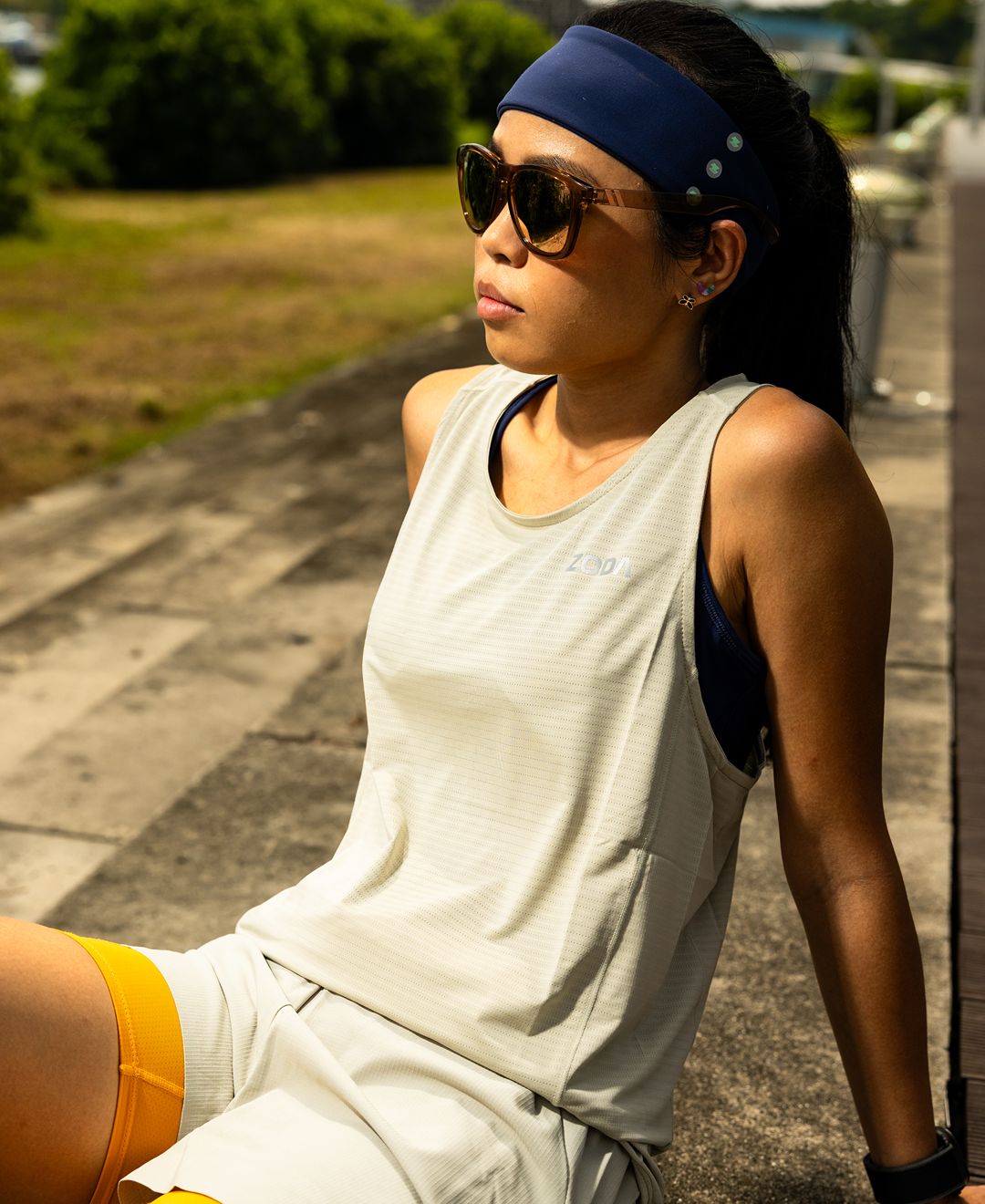 Woman in athletic wear sitting outdoors on a path Zoda Pulse Collection
