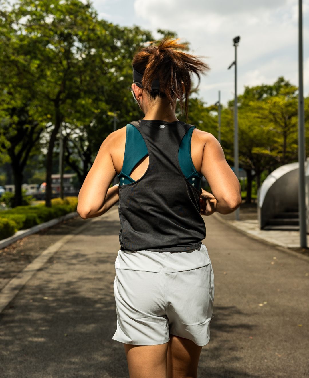 Person running on a path with trees and a building in the background Zoda Pulse Collection