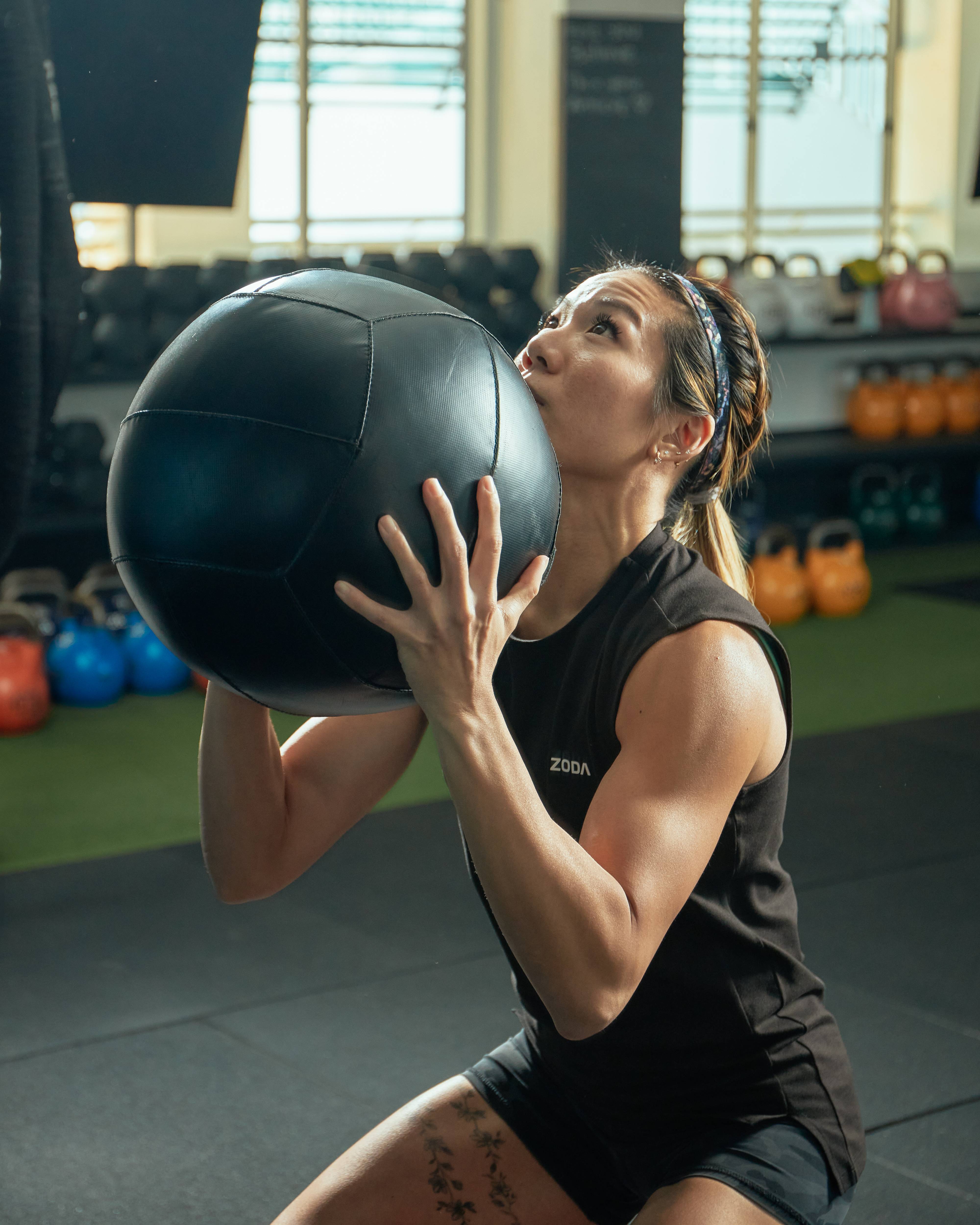 Woman exercising with a medicine ball in a gym setting Zoda.sg