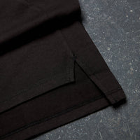 Folded black fabric on a textured dark surface Zoda.sg