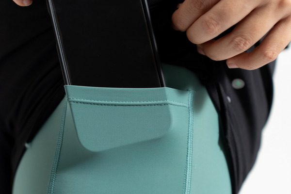 Close-up of a person wearing a teal apron with a black background Training wear - Zoda.sg In it to win it, Singapore