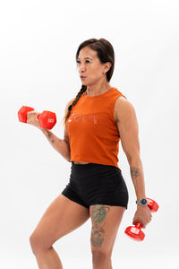 A person working out wearing a burnt orange cropped tee and black shorts. Zoda.sg