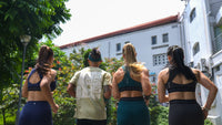 Four people in athletic wear running outdoors with a building and trees in the background Zoda.sg