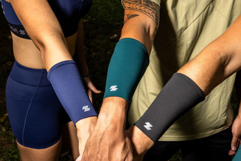 Two people wearing compression sleeves on their arms with a brand logo. Zoda.sg