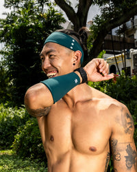 Man wearing a teal headband and arm sleeve outdoors Zoda.sg